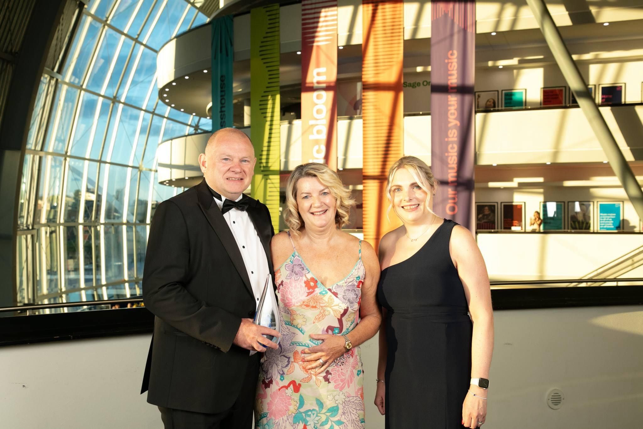 Principle and Vice Principle holding award alongside a lady